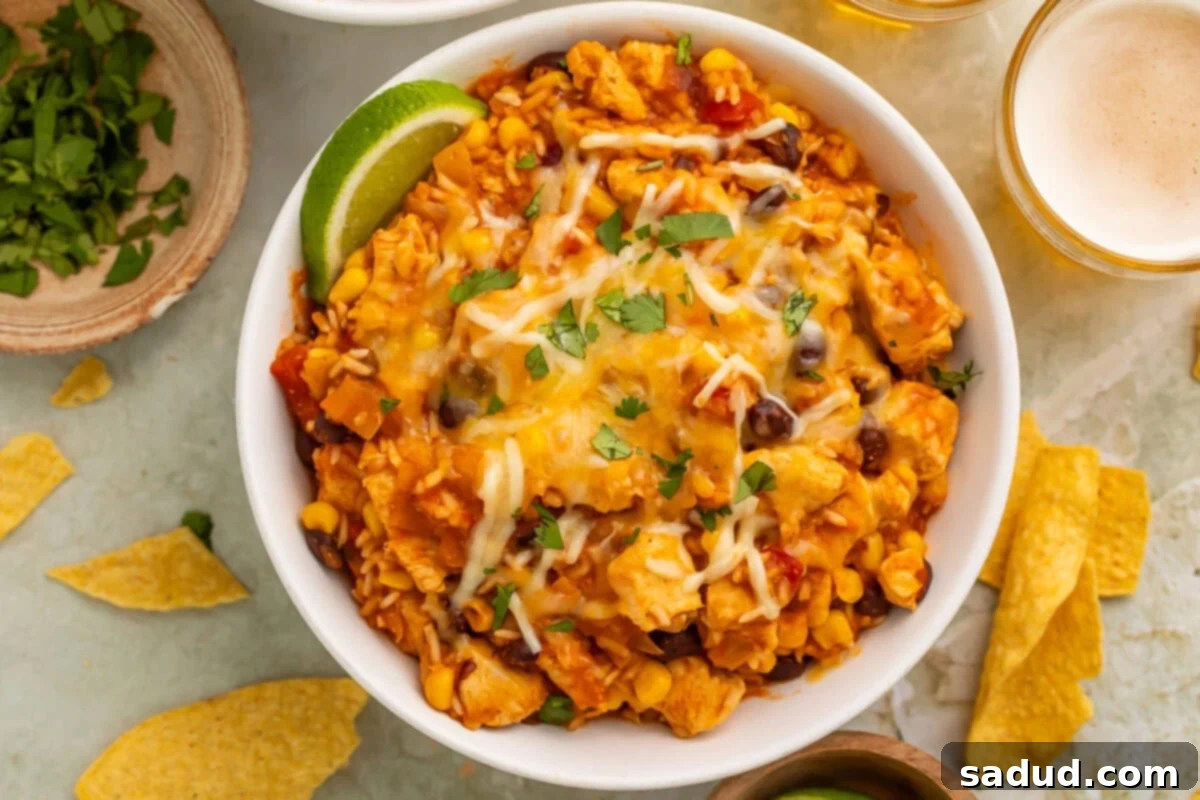 Instant Pot Chicken and Bean Fiesta Bowls 3 Overhead photo of a chicken burrito bowl with rice, cooked in the Instant Pot, on a table surrounded by lime wedges and a glass of white wine.