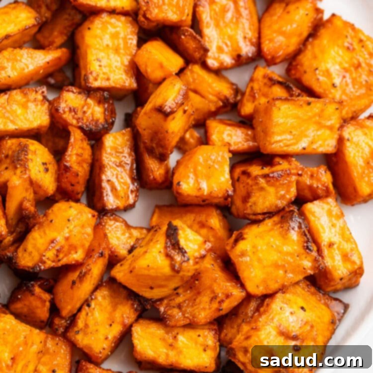 Sweet potato cubes, cooked in the air fryer, shown on a white plate.
