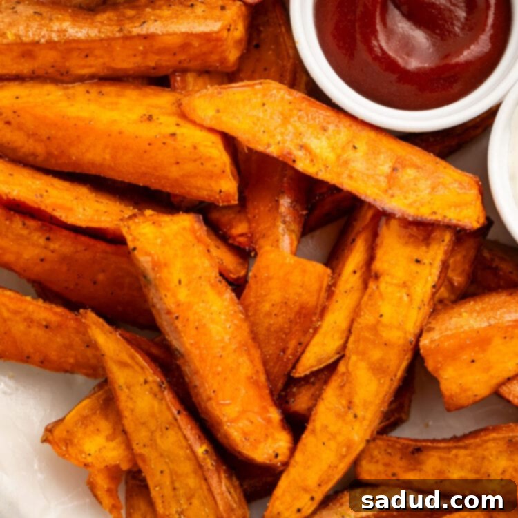 A plate of sweet potato wedges cooked in the air fryer and served with ketchup.