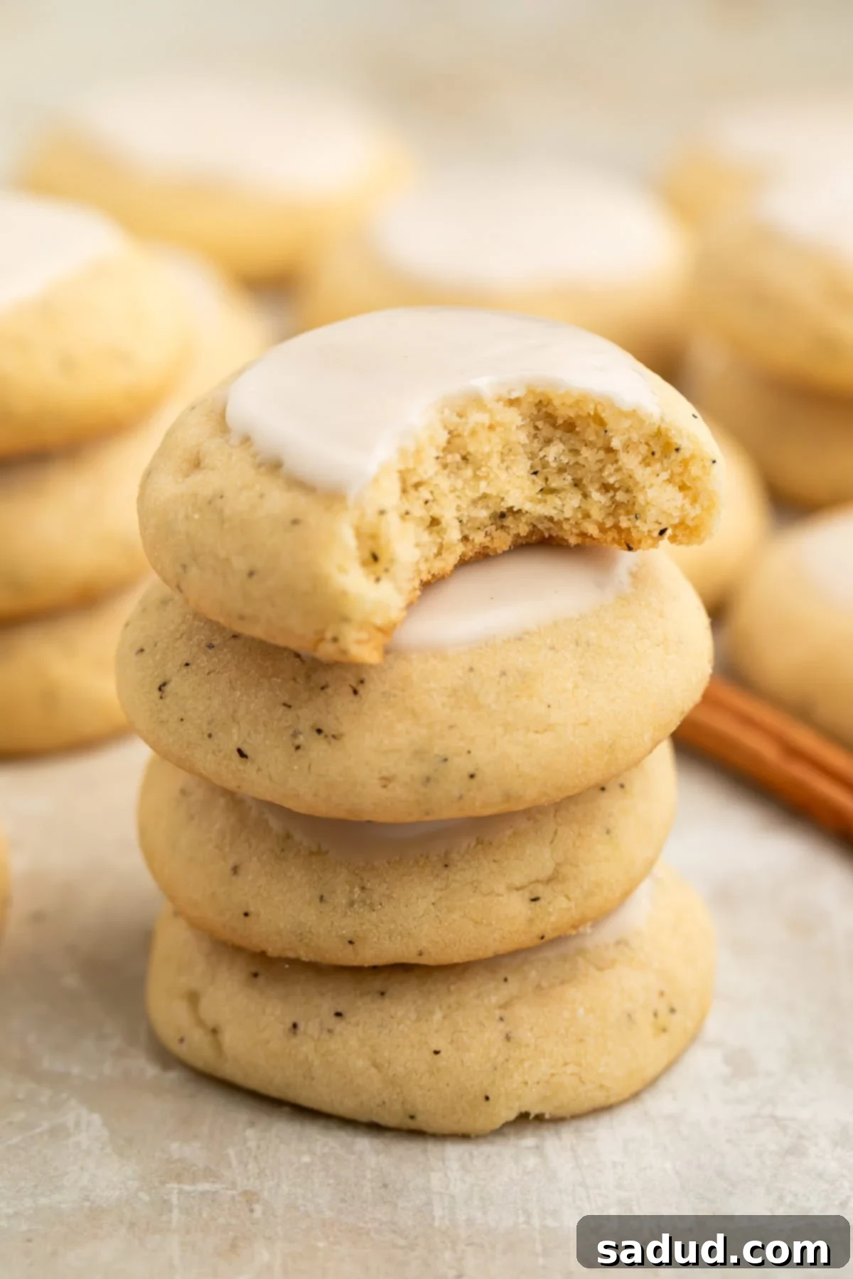 Four perfectly stacked Taylor Swift chai cookies, with a bite missing from the top one, showcasing the soft interior and the delicate glaze.
