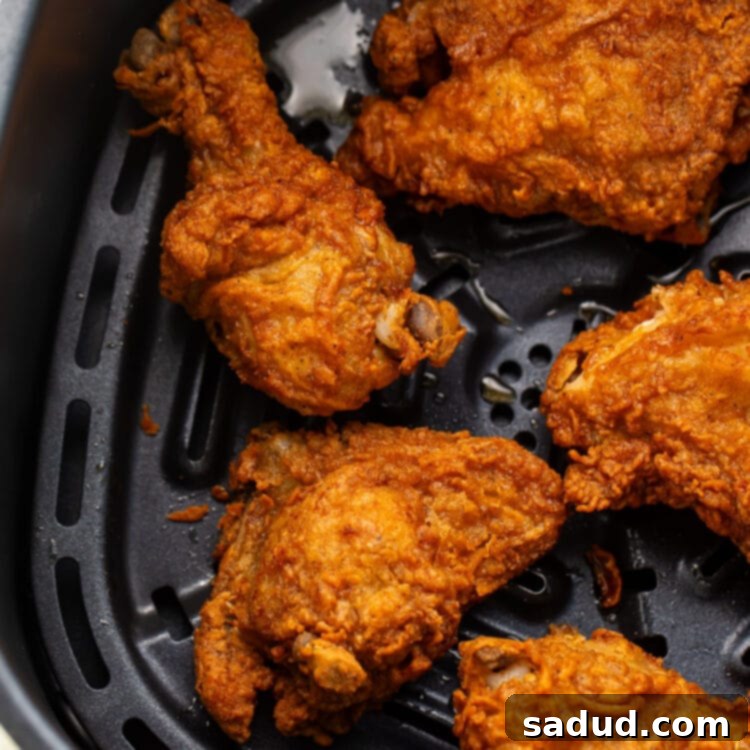 Reheat Fried Chicken to Crispy Perfection in Your Air Fryer 4 Crispy reheated fried chicken legs, thighs, and breasts in an air fryer basket.
