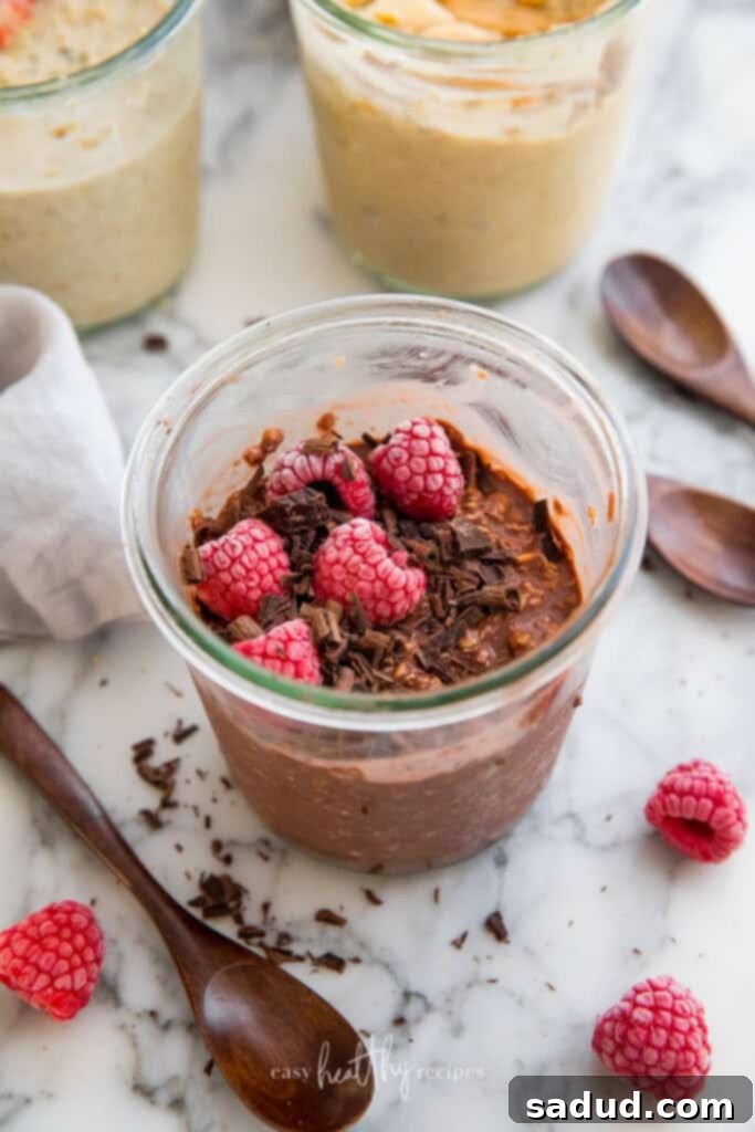 Rich chocolate vegan overnight oats topped with delicate chocolate shavings and fresh raspberries.