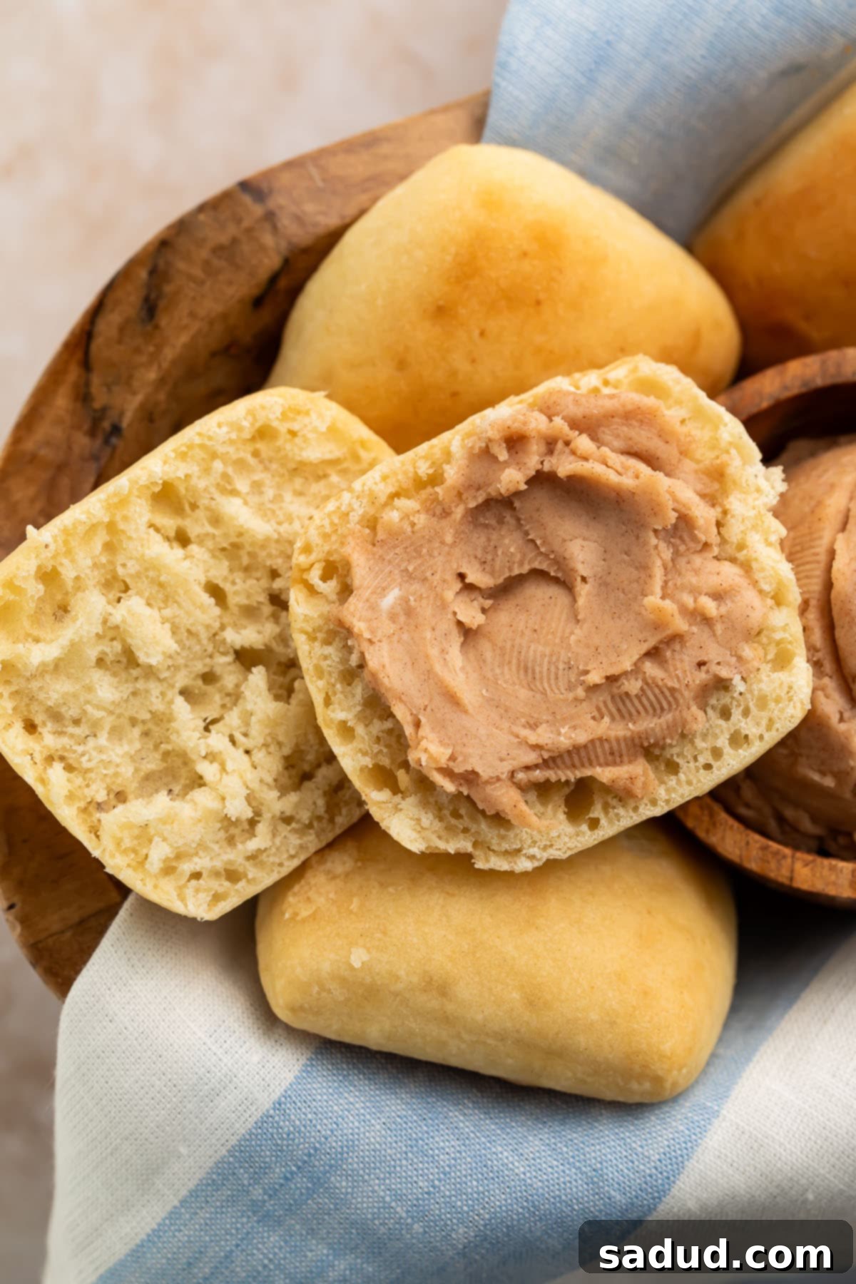 Homemade Texas Roadhouse cinnamon honey butter spread thickly on a golden brown roll.