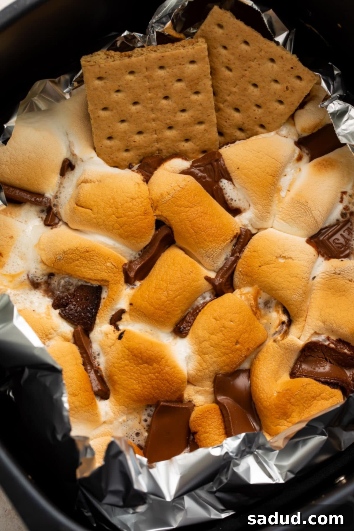 Air fryer s'mores dip in an air fryer basket lined with aluminum foil.