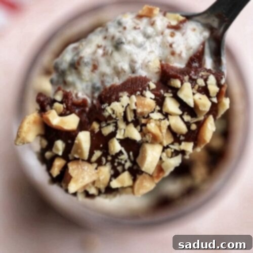 Delicious Snickers Chia Pudding in a jar with toppings.