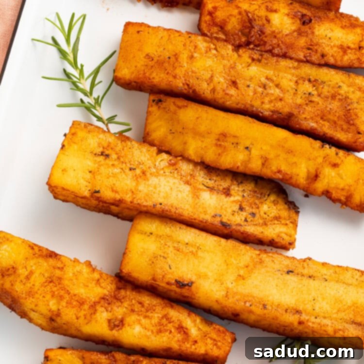 Smoked Pineapple 5 Smoked pineapple spears arranged in a staggered row in a white rectangular baking dish.