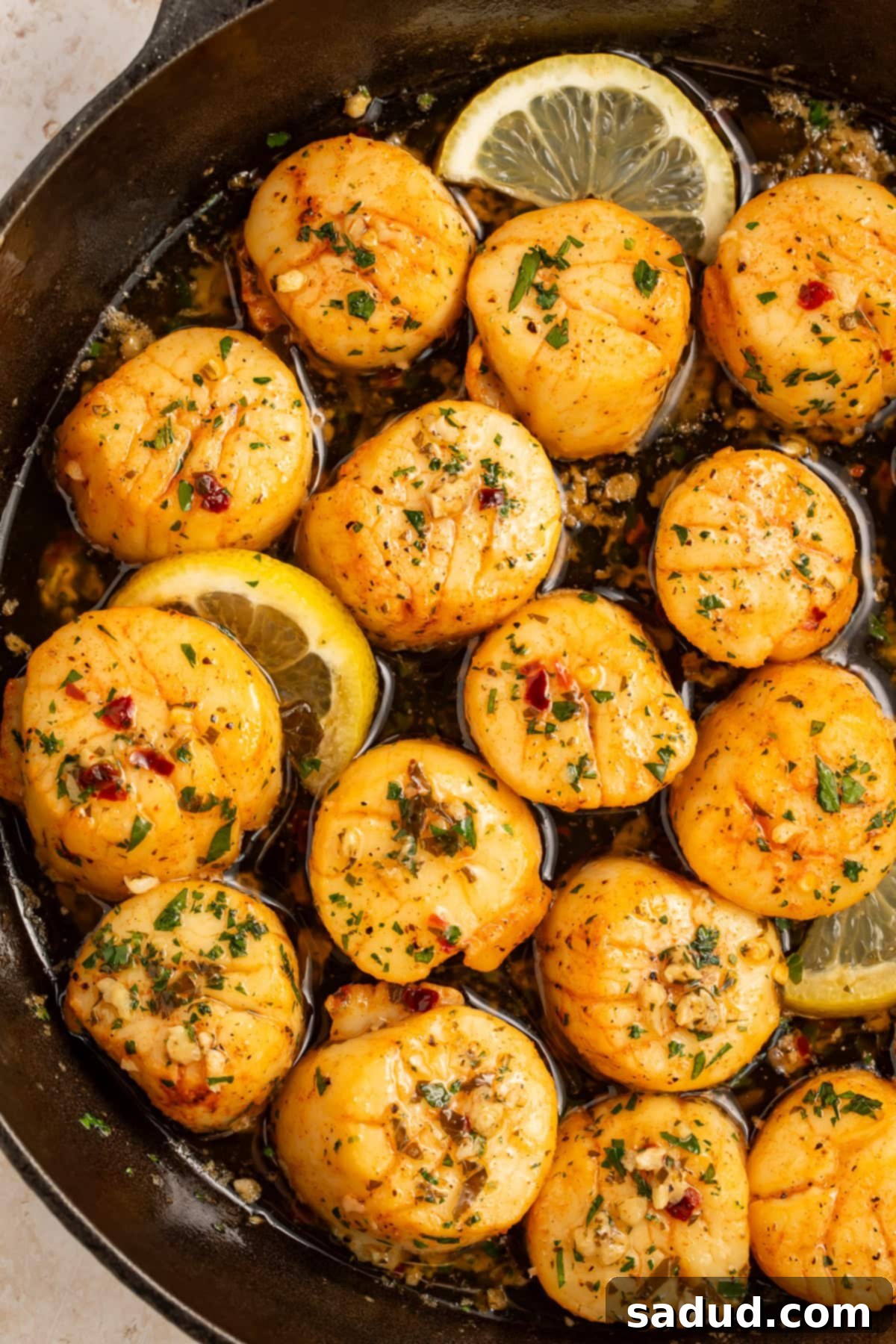 Scallops with a lemon, garlic and herb butter in a cast iron skillet.