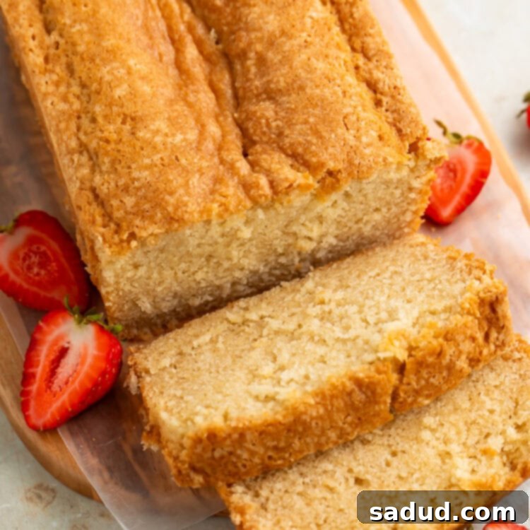 Top down picture of a sliced pound cake on a wooden board.