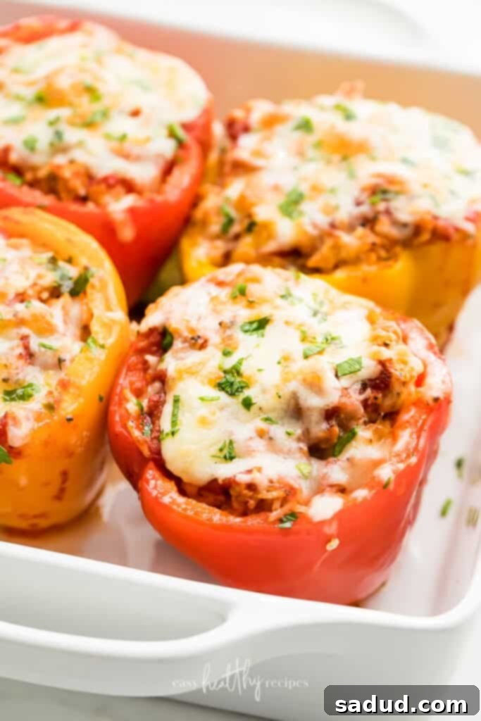 Delicious Turkey Stuffed Peppers in a white casserole dish, generously topped with melted golden-brown cheese and garnished with fresh parsley. A perfect healthy weeknight meal.