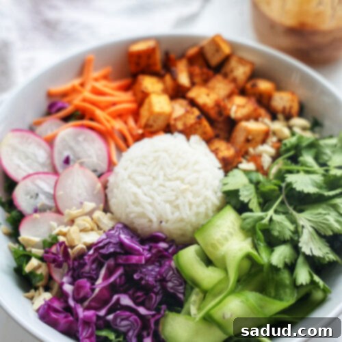 A close-up shot of the Thai Nourish Bowl with crispy tofu and vegetables.