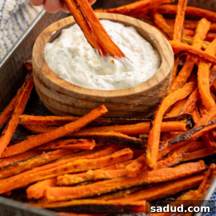 Crispy Carrot Fries 5 Carrot fry from a tray of them being dipped into a wooden bowl of creamy dip.