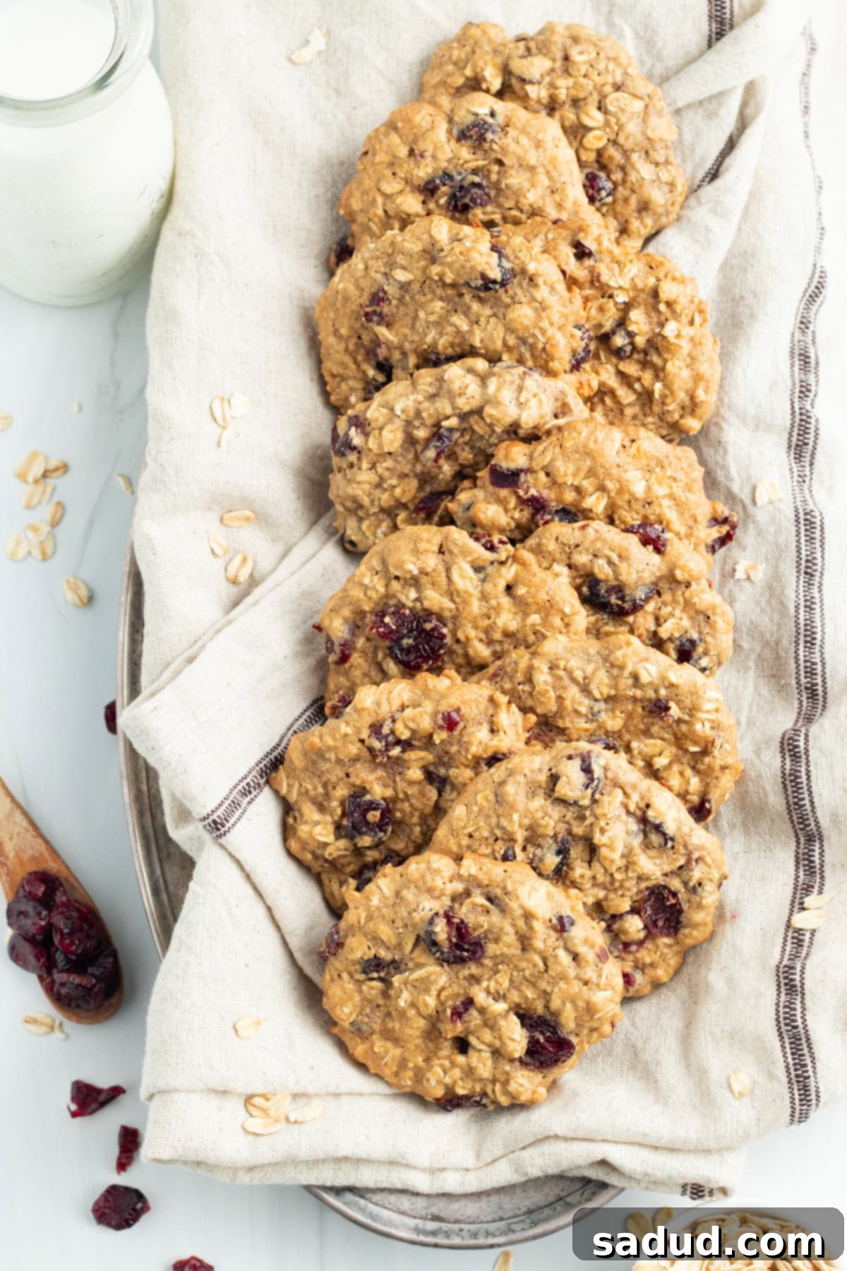 Overhead view of oatmeal cranberry cookies in a napkin-lined basket on a table.