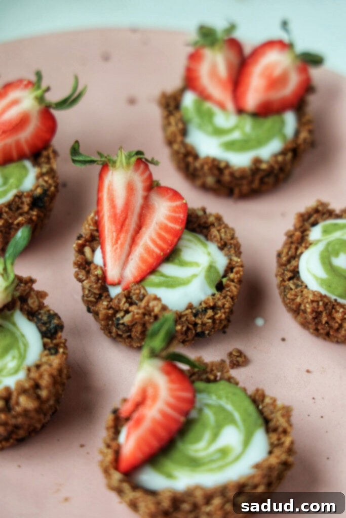 A close-up of a single strawberry matcha granola tart with a perfectly swirled top.