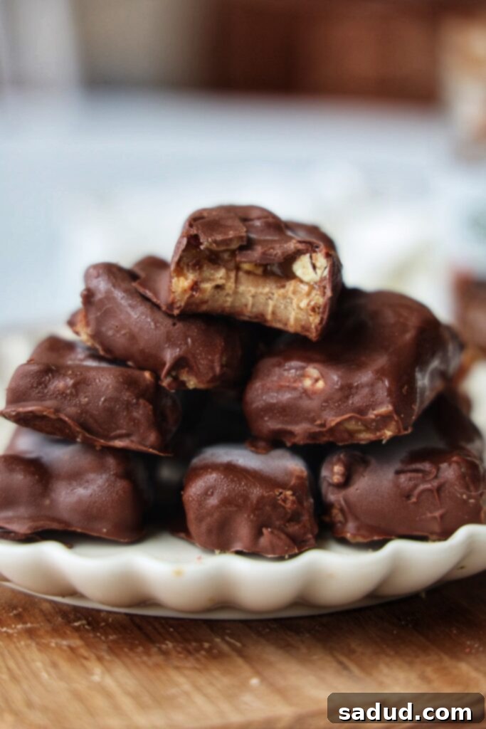 A closer look at a cut healthier pecan snickers bar, revealing its distinct nougat, caramel, and pecan layers.