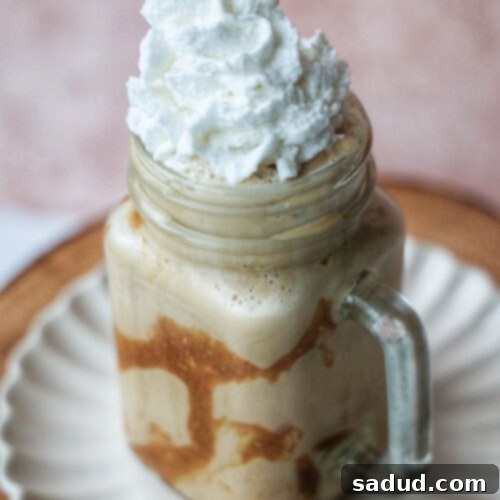 Vegan Caramel Ribbon Crunch Frappuccino with whipped cream and caramel drizzle.