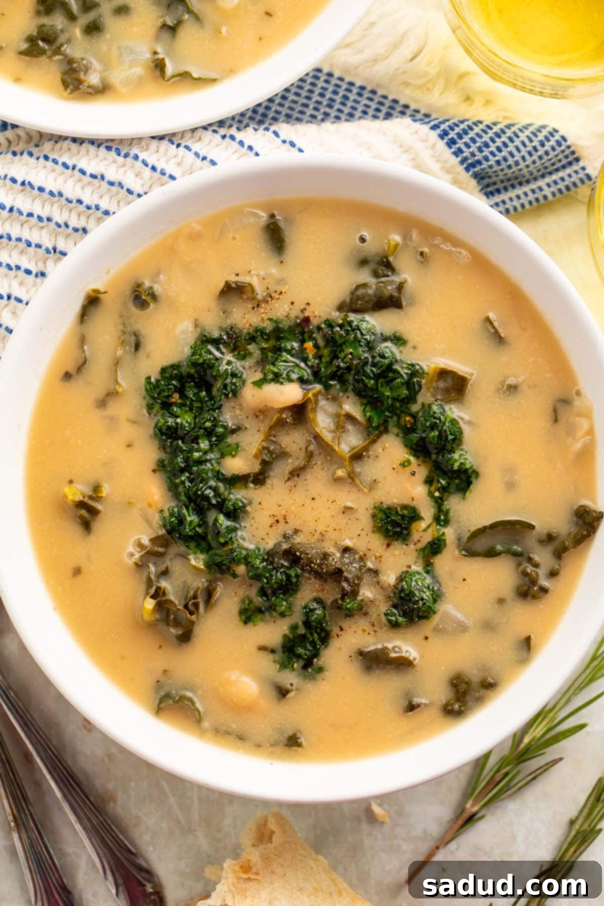 Top-down view of a bowl of creamy kale and white bean soup finished with gremolata. A perfect, comforting vegan and healthy meal for any season.