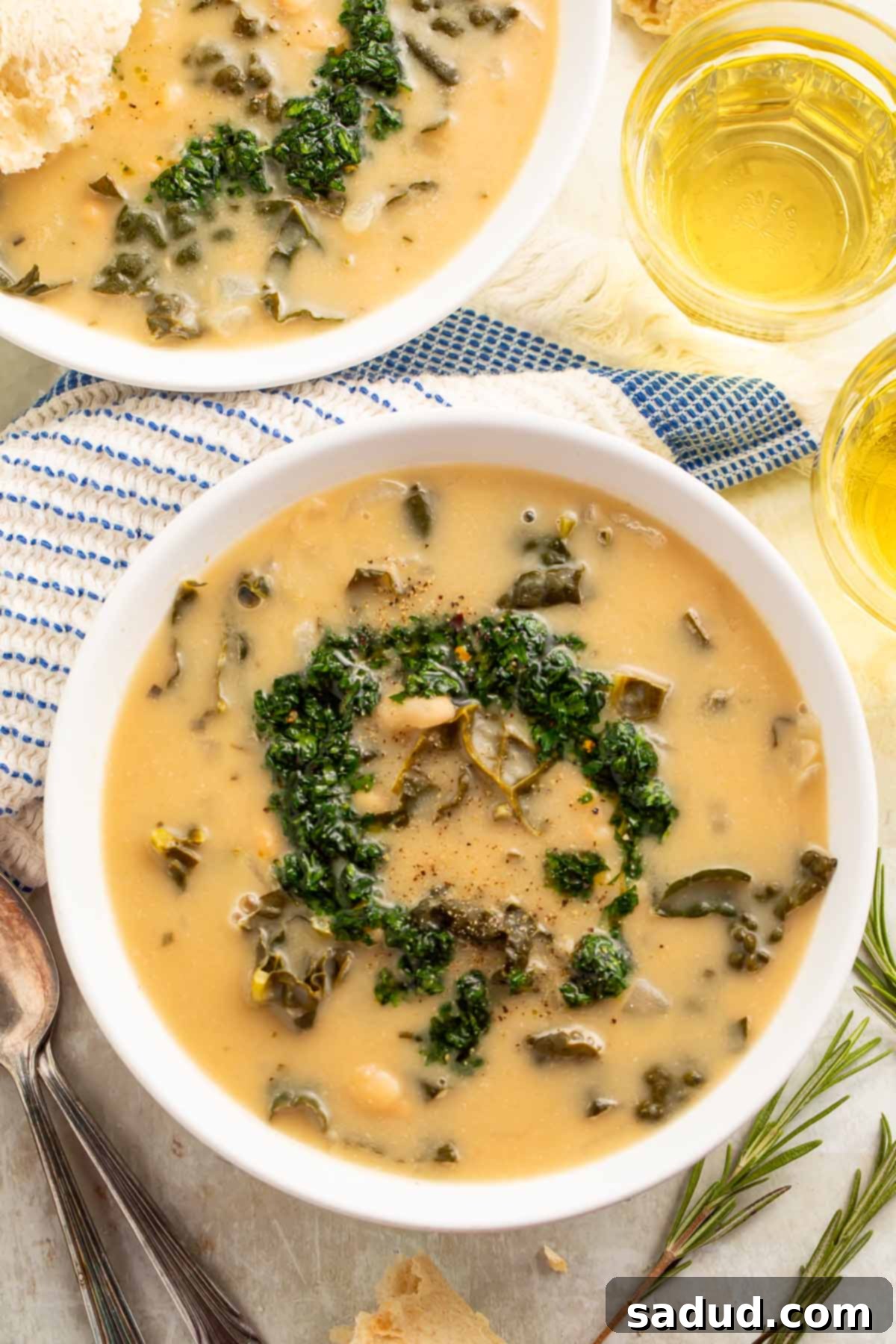 Top-down view of a bowl of creamy kale and white bean soup finished with gremolata, showcasing its rich texture and vibrant topping.