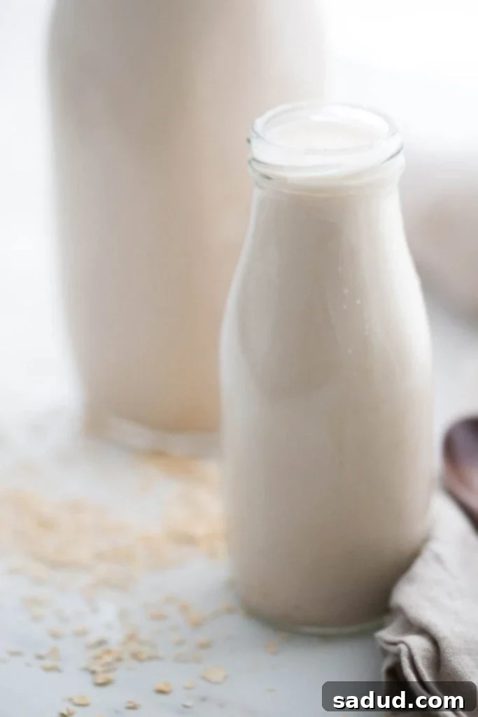 close up image of homemade oat milk, fresh and creamy in a glass