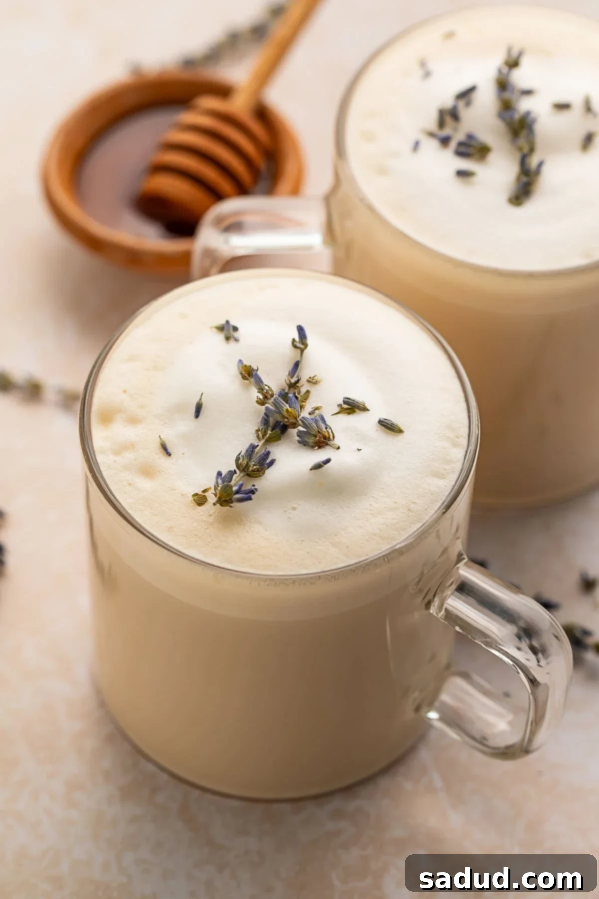 A perfectly prepared London Fog latte in a clear glass mug sitting on a rustic wooden table, ready to be enjoyed.