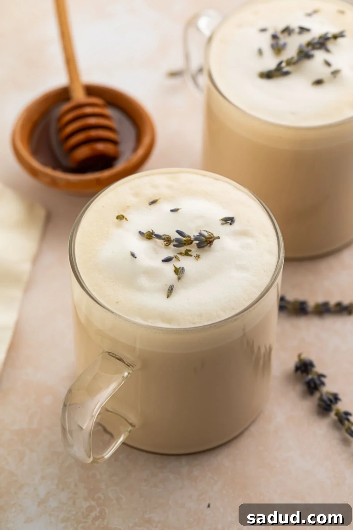Close-up of a London Fog latte in a clear glass mug, highlighting the layers of tea and frothy milk.