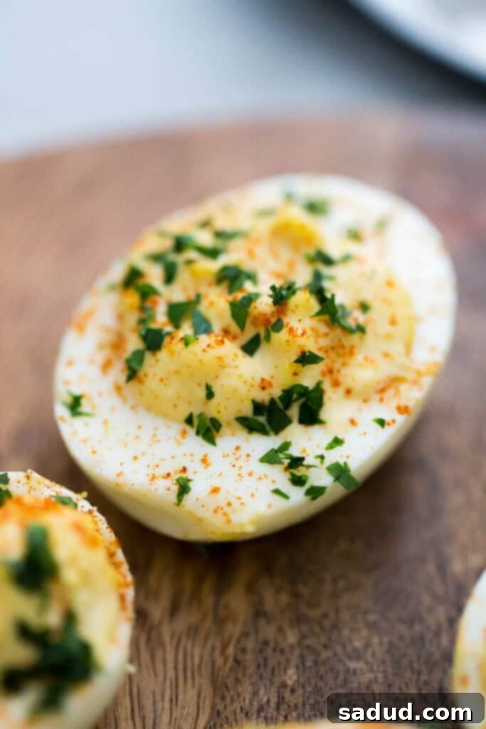 Close-up shot of perfectly prepared classic deviled eggs, garnished with paprika, on a serving platter.