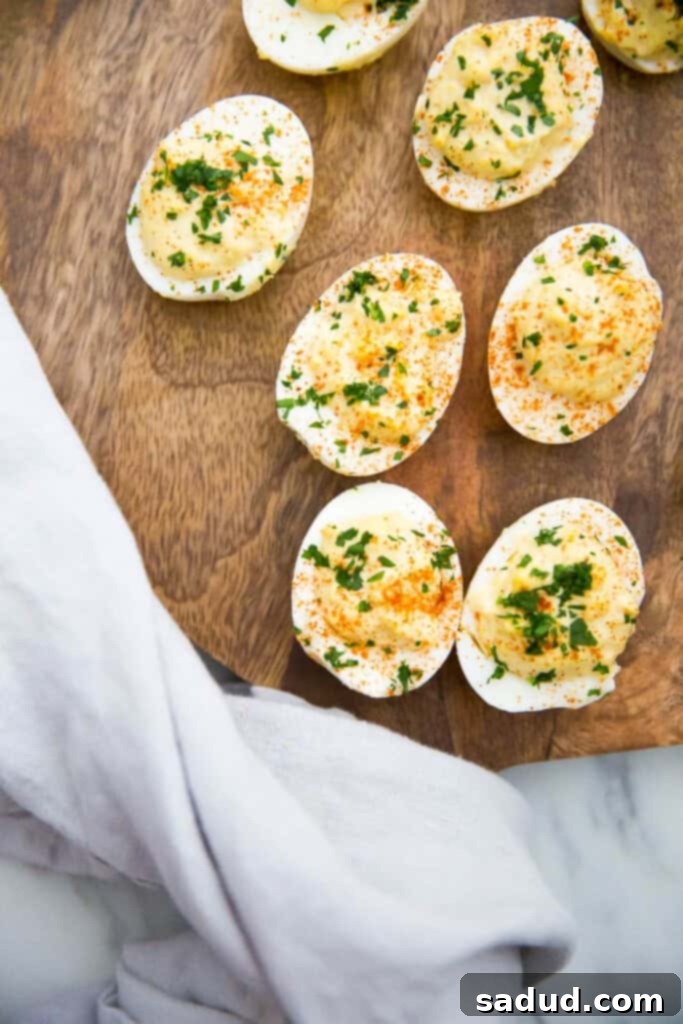 Overhead shot of classic deviled eggs, artfully arranged on a wooden serving platter, ready to be enjoyed.