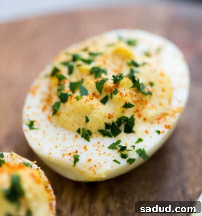 A vibrant platter of classic deviled eggs, ready to be served, highlighting their creamy texture and paprika garnish.
