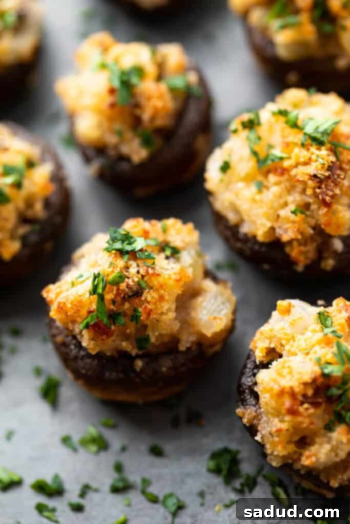 Close-up of golden brown vegetarian stuffed mushrooms on a platter, garnished with fresh parsley.