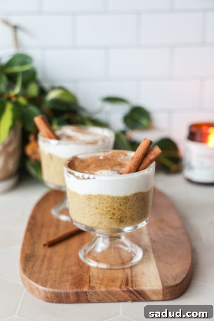 Two jars of creamy pumpkin chia pudding topped with a layer of vanilla yogurt and a sprinkle of cinnamon, ready to be enjoyed as a healthy fall breakfast or dessert.