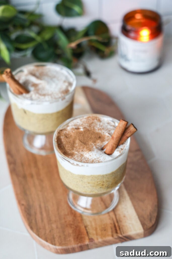 Two clear jars of pumpkin chia pudding, one topped with vanilla yogurt and cinnamon, the other with a plain, smooth surface.