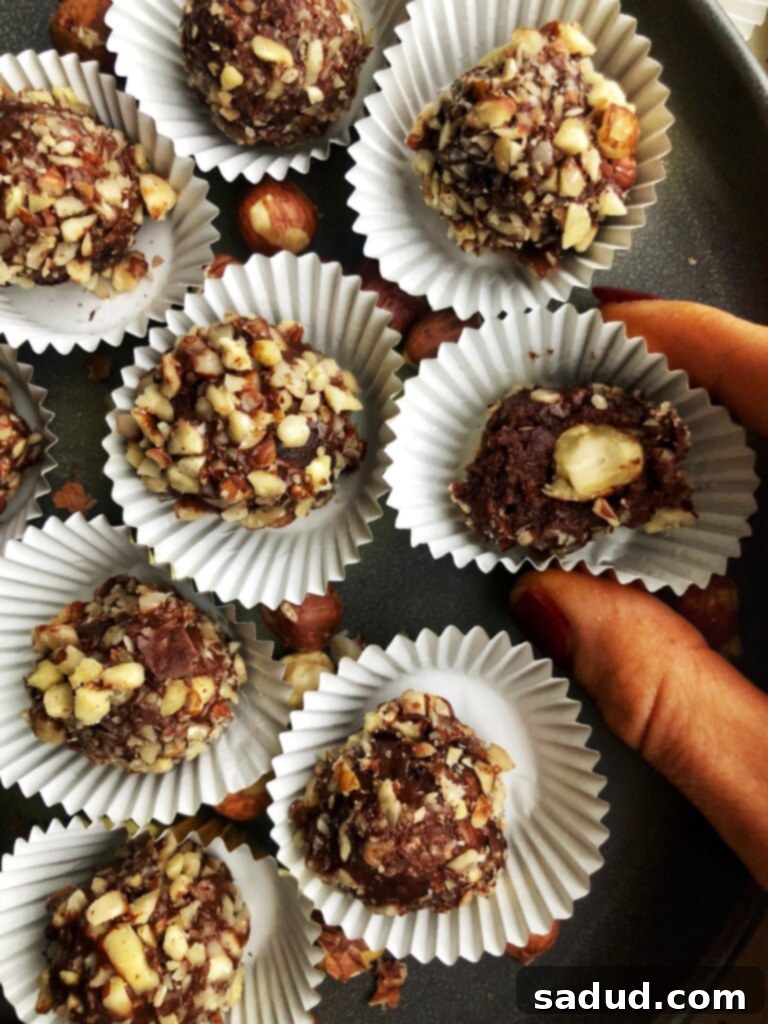A plate of homemade raw vegan Ferrero Rochers, rich in chocolate and hazelnut flavor.