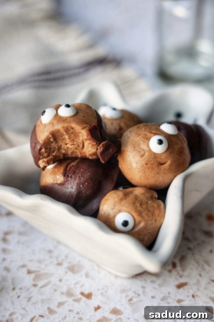 Wicked Wholesome Vegan Halloween Recipes 3 Healthy Halloween Buckeyes - Partially dipped in chocolate with a peanut butter center exposed.