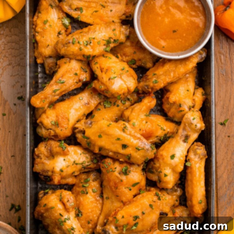 Sweet Heat Mango Habanero Wings 4 A pan of juicy chicken wings in an orange mango habanero sauce.
