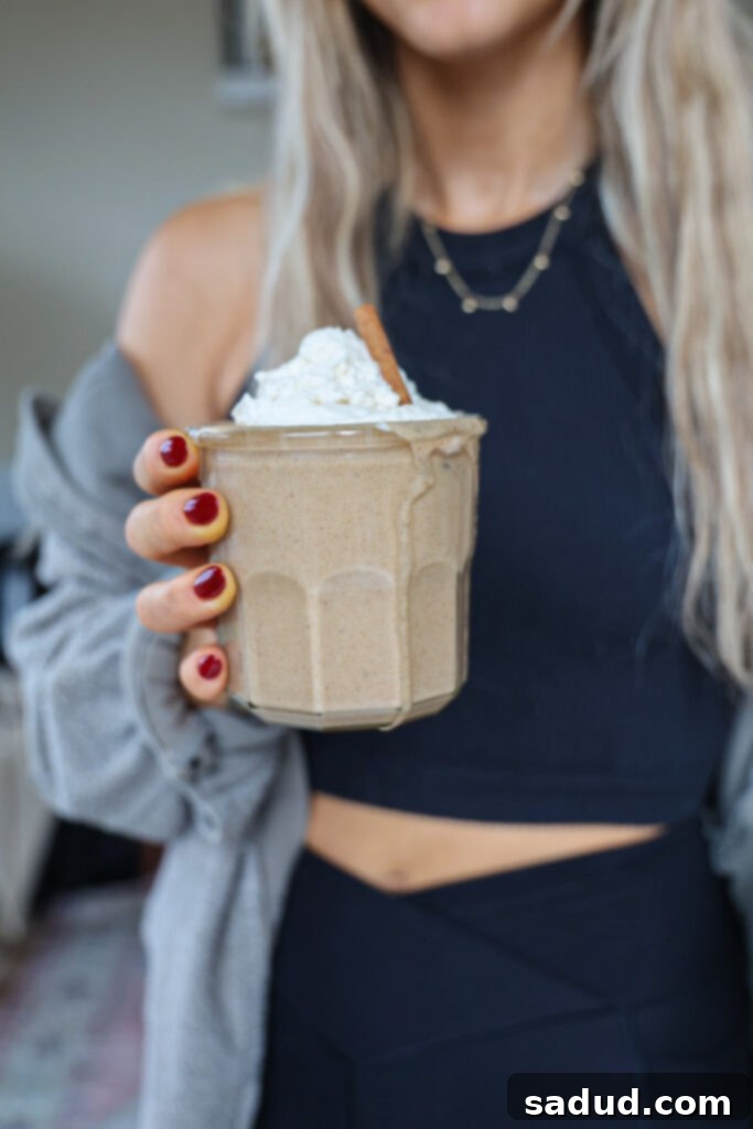 Holding an eggnog shake topped with whipped cream.