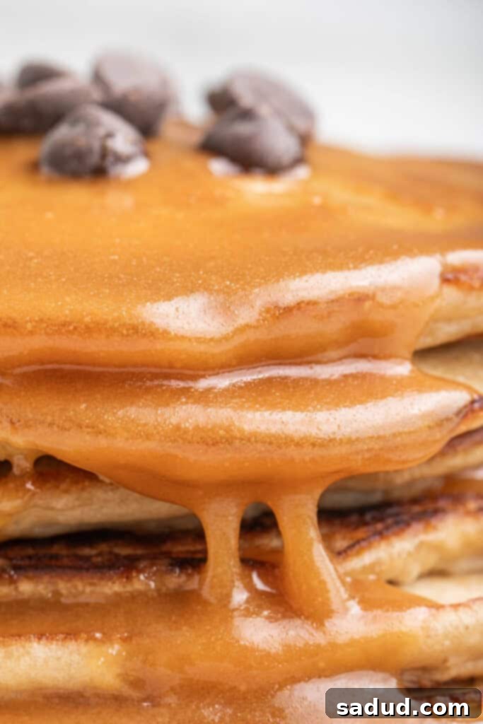 Peanut butter maple syrup on a stack of golden pancakes with a pat of butter, inviting and delicious