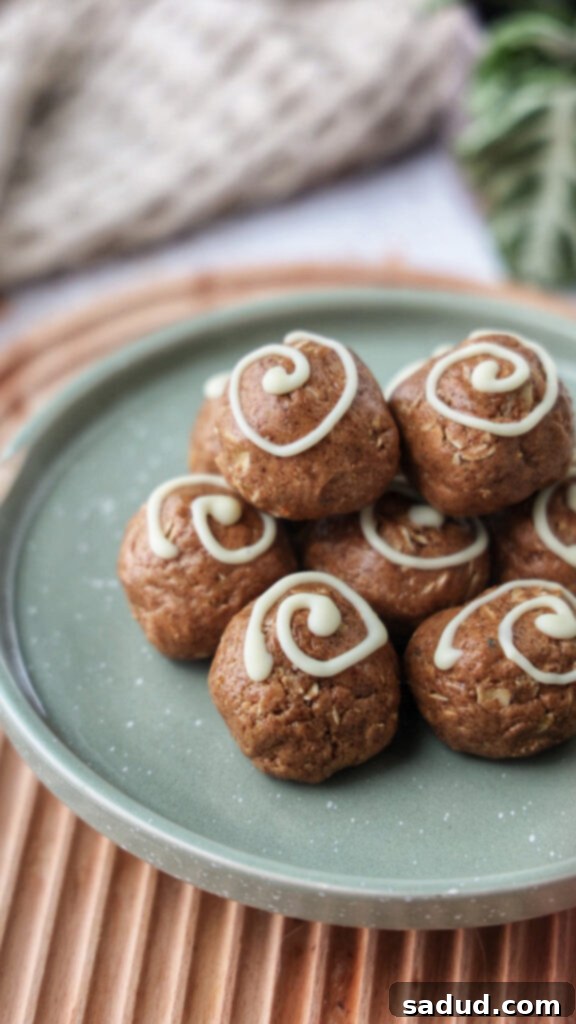 A plate of vegan cinnamon roll energy bites with white chocolate drizzle.