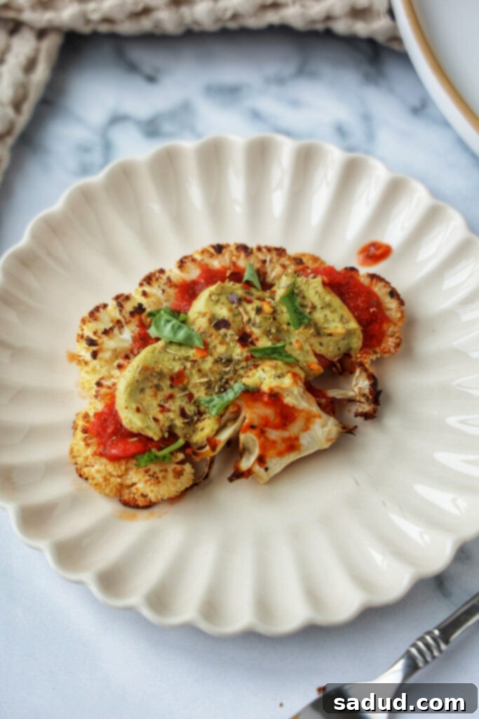 Cauliflower steak pizza on a plate, ready to be eaten.