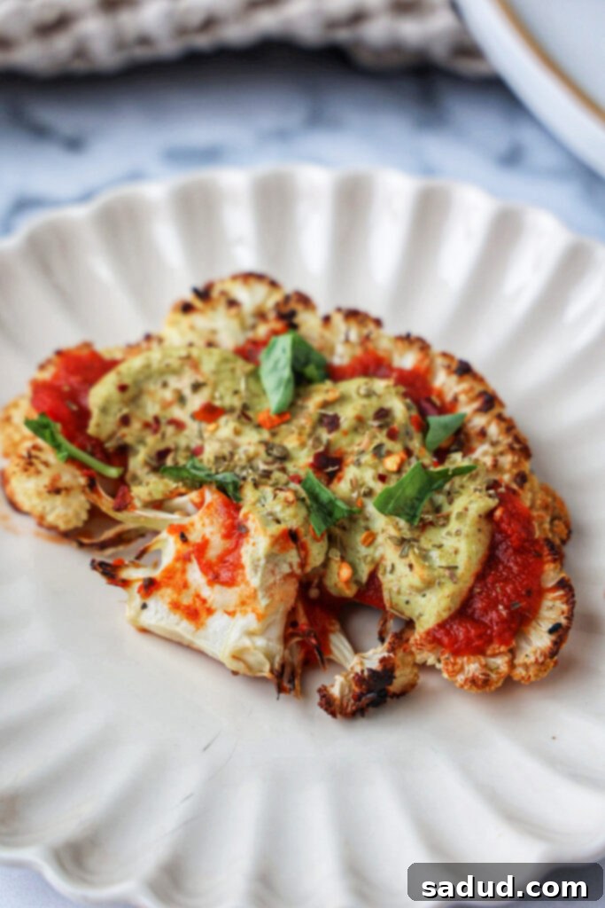 Close up shot of cauliflower steak pizza with melted cheese and toppings.