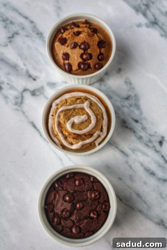 Three ramekins of viral blended baked oats, showing chocolate chip cookie, cinnamon roll, and brownie batter variations side by side.