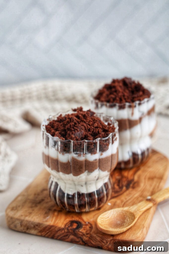 Guilt-Free Vegan Gluten-Free Brownie Trifle 2 Healthier brownie trifle, beautifully layered in a glass dish with chocolate, cream, and brownie pieces.