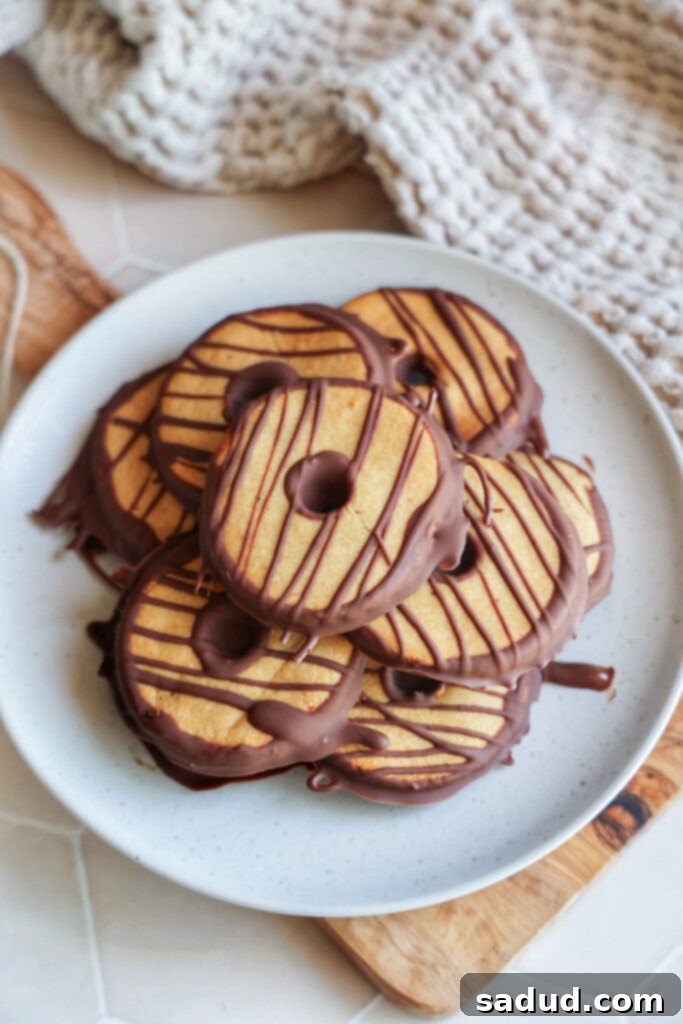 Effortless 3-Ingredient Fudge Stripe Cookies 2 A plate of freshly baked vegan fudge stripe cookies, showing their perfect shape and chocolate drizzle.
