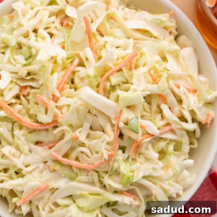A large bowl of copycat Chick-fil-a coleslaw on a red and white checkerboard tablecloth.