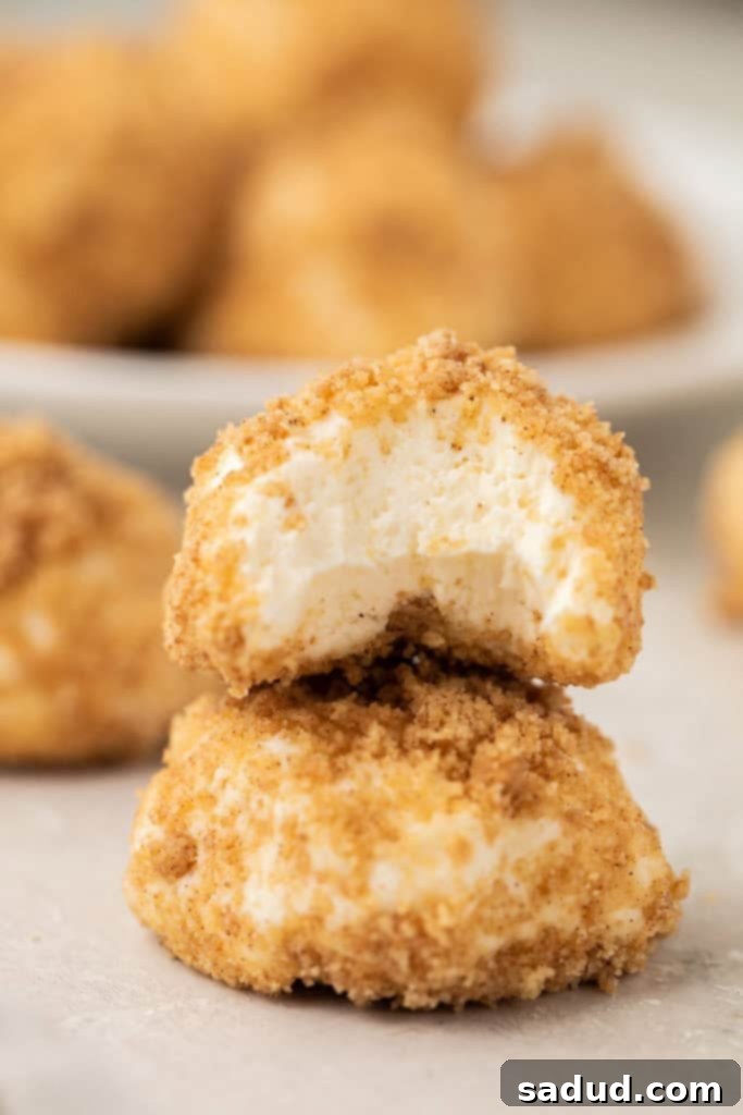 Cheesecake-like cream cheese fat bombs stacked, with a delicious bite taken from the top one, revealing creamy texture