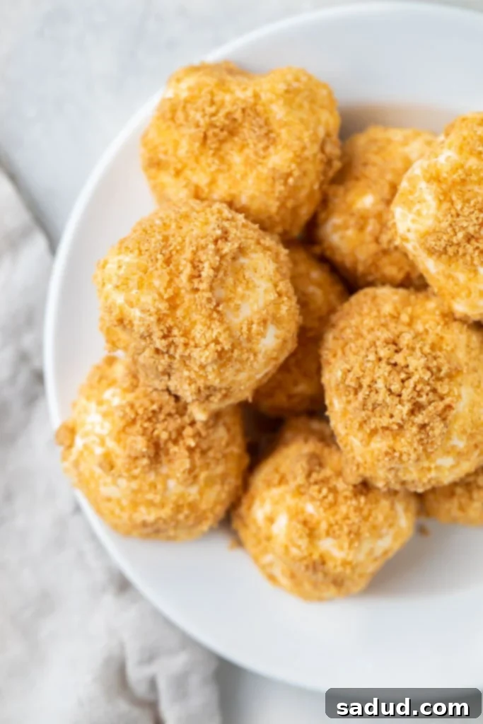 Close up shot of a delightful mountain of creamy, coated cream cheese fat bombs piled high on a pristine white plate, showcasing their inviting texture