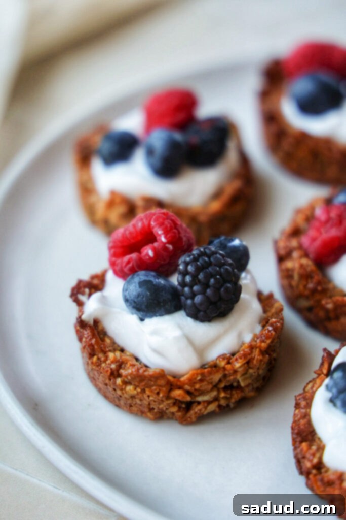 A plate of yogurt granola cups topped with berries, showcasing their vibrant colors and appealing texture.