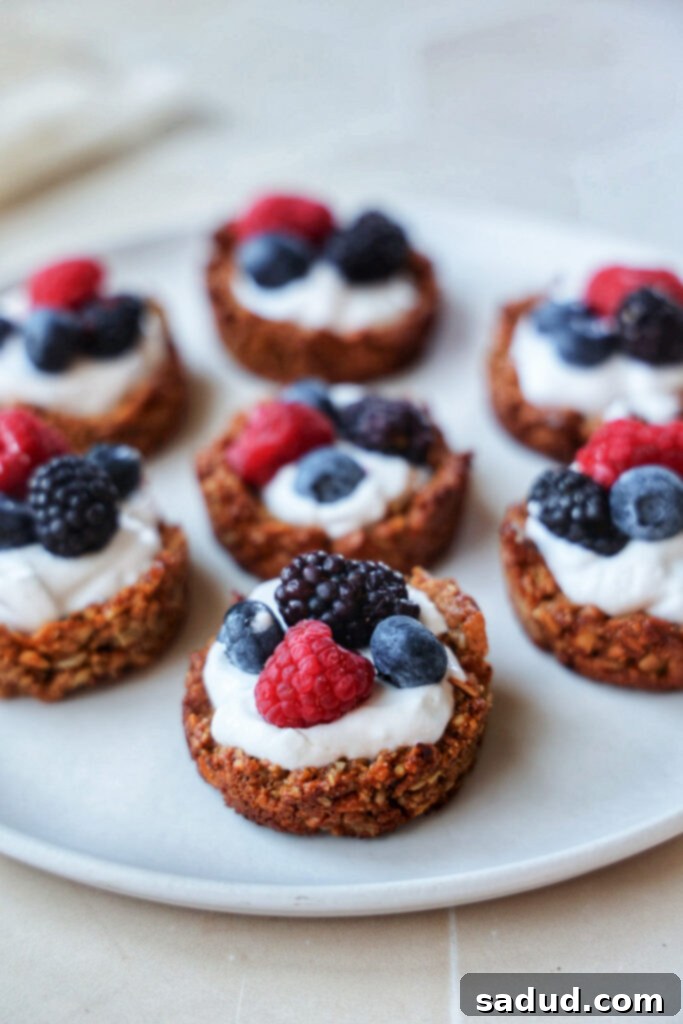 A close-up of a single yogurt granola cup, perfectly formed with layers of granola, yogurt, and fresh berries.