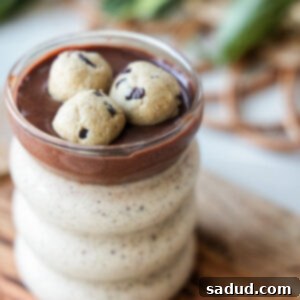 Finished Cookie Dough Blended Oats topped with a thick chocolate layer, garnished with chocolate chips, presented in a glass jar.