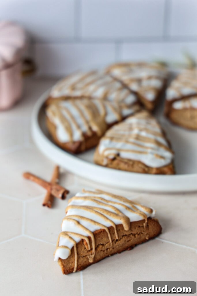 Close-up of a pumpkin spice scone with maple glaze, showing its tender crumb.