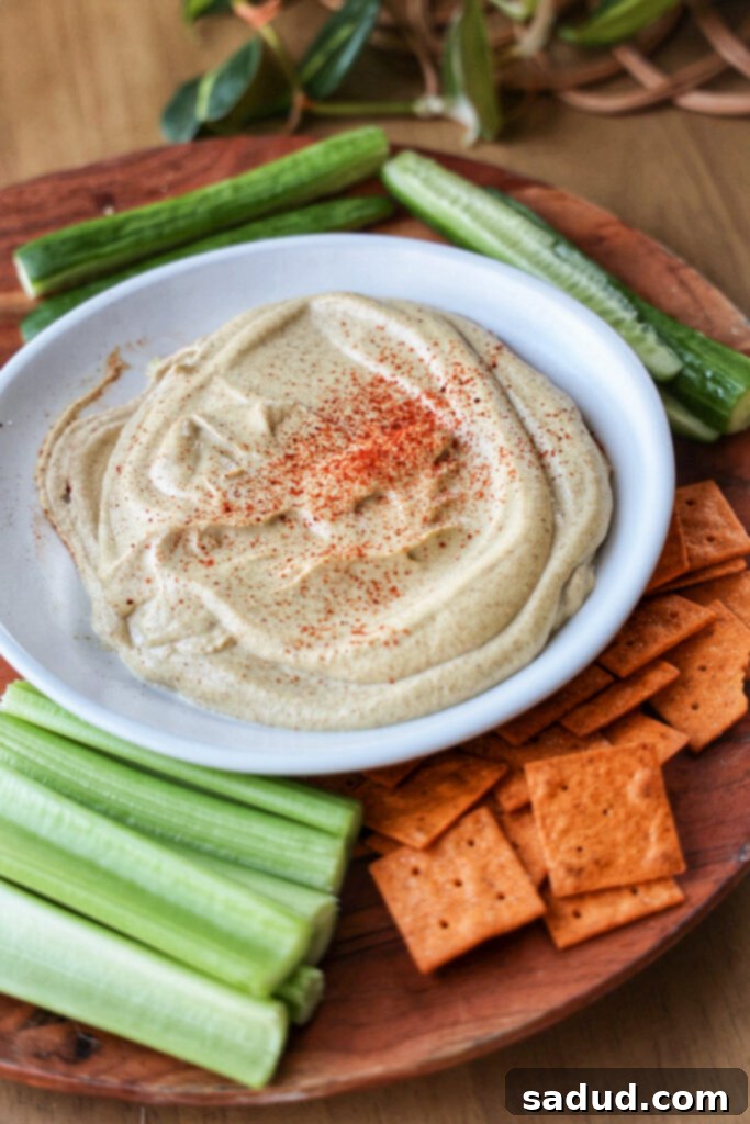 A bowl of creamy, homemade copycat bitchin' sauce, garnished with fresh herbs.