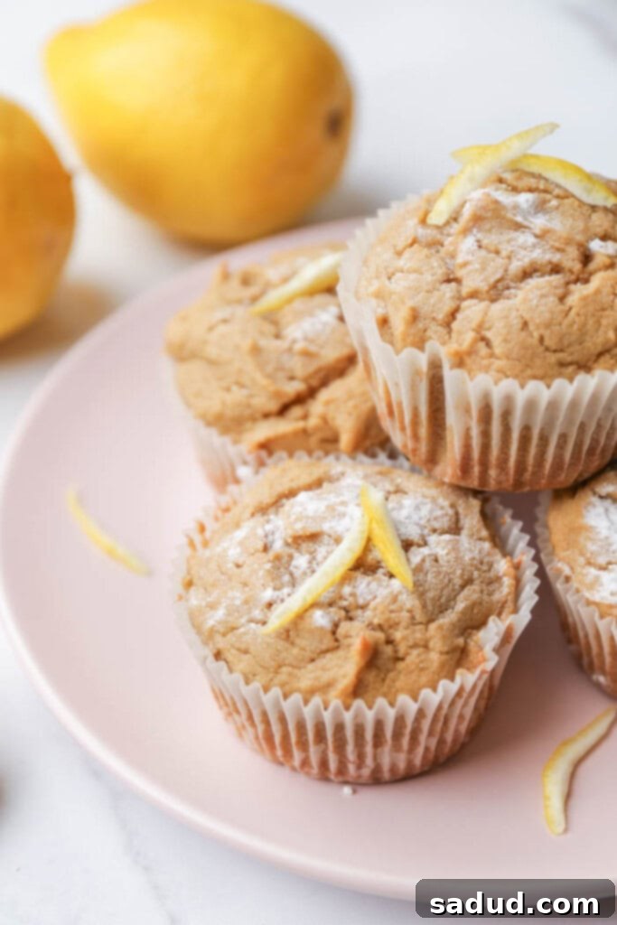 Close-up of fluffy healthy lemon muffins on a stylish pink plate, ready to be enjoyed